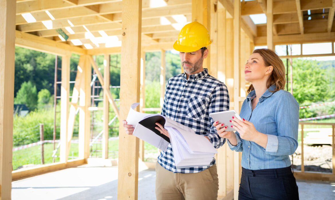 Constructeurs homme et femme analysant les travaux dans une maison en construction