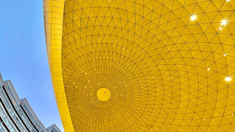 Valeurs Edifitek : Architecture avec grand cercle d'acier jaune sur fond bleu
