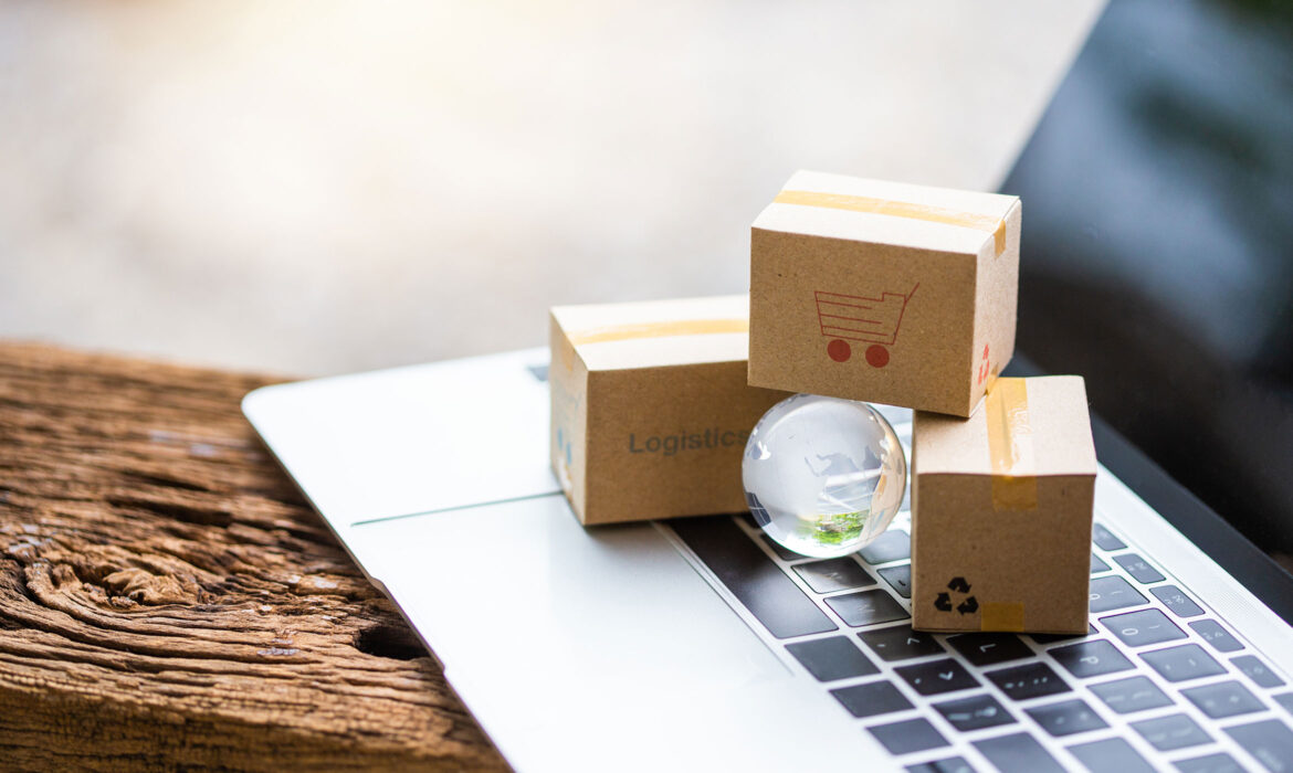 Petites boites en cartons posées sur un clavier d'ordinateur avec une bille en vert au centre.